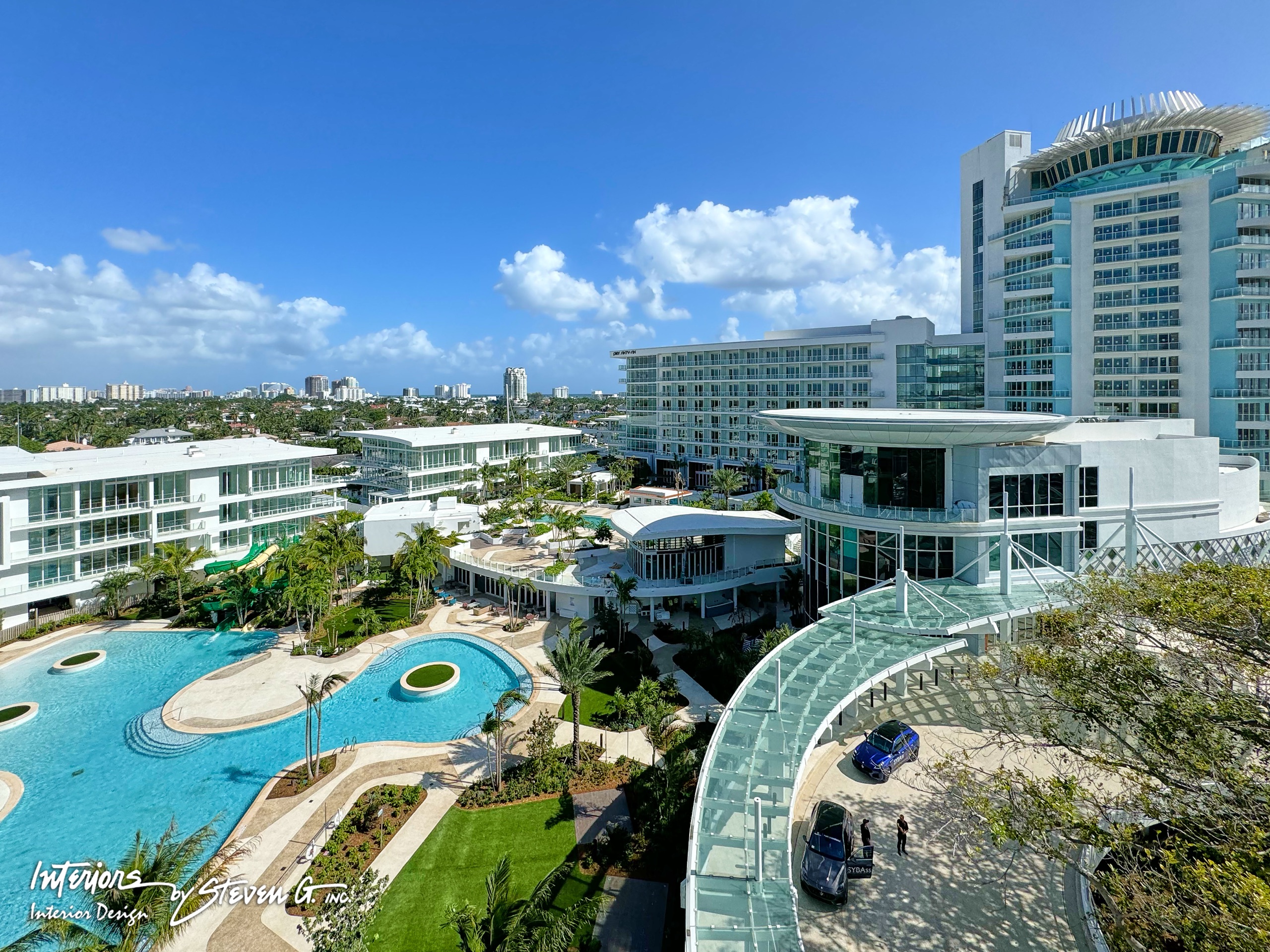 From a residence terrace: the pools, the porte-cochère and the crowned tower