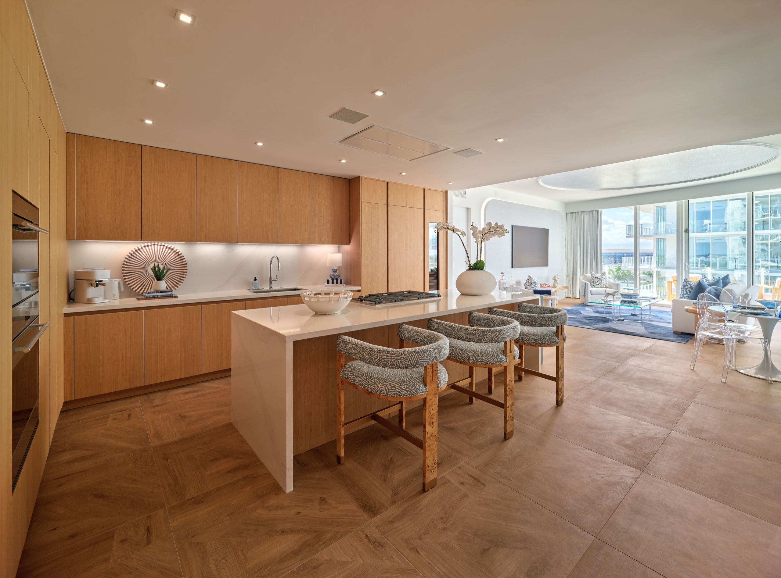 The kitchen as delivered: oak, quartz waterfall island, living room beyond