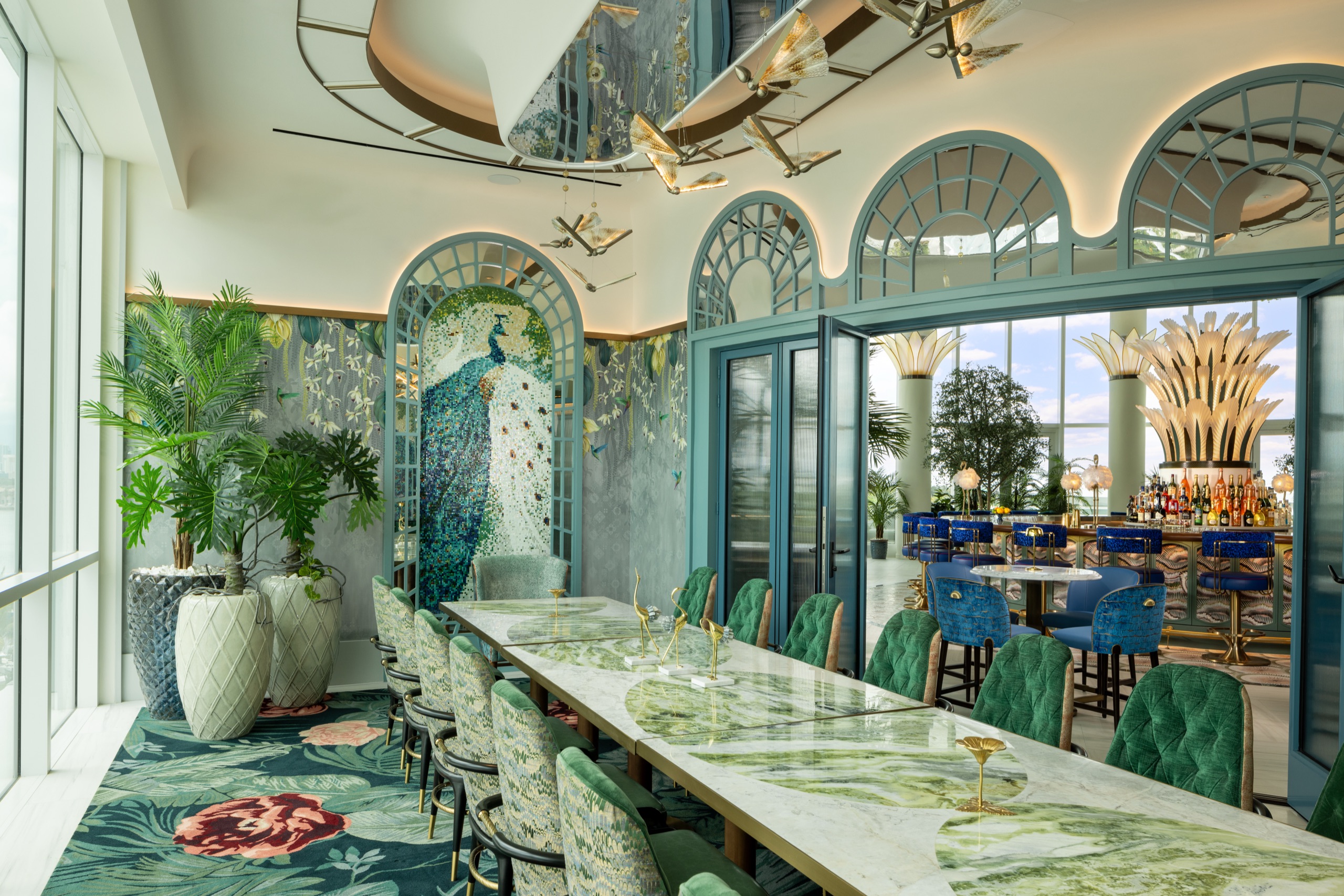 A private dining room lined with a peacock mosaic and green velvet
