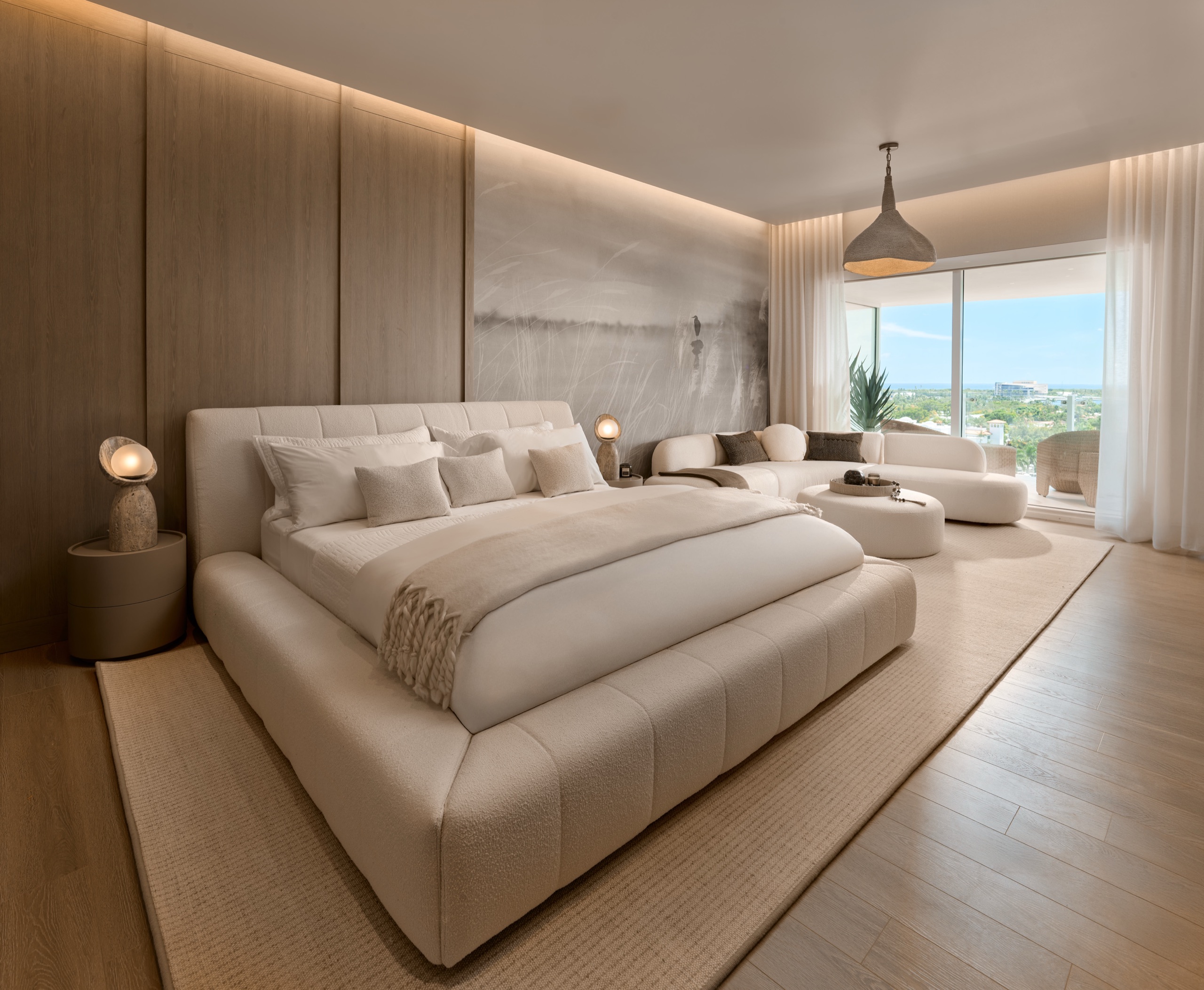 A finished primary suite in oak and boucle, the ocean past the curtains
