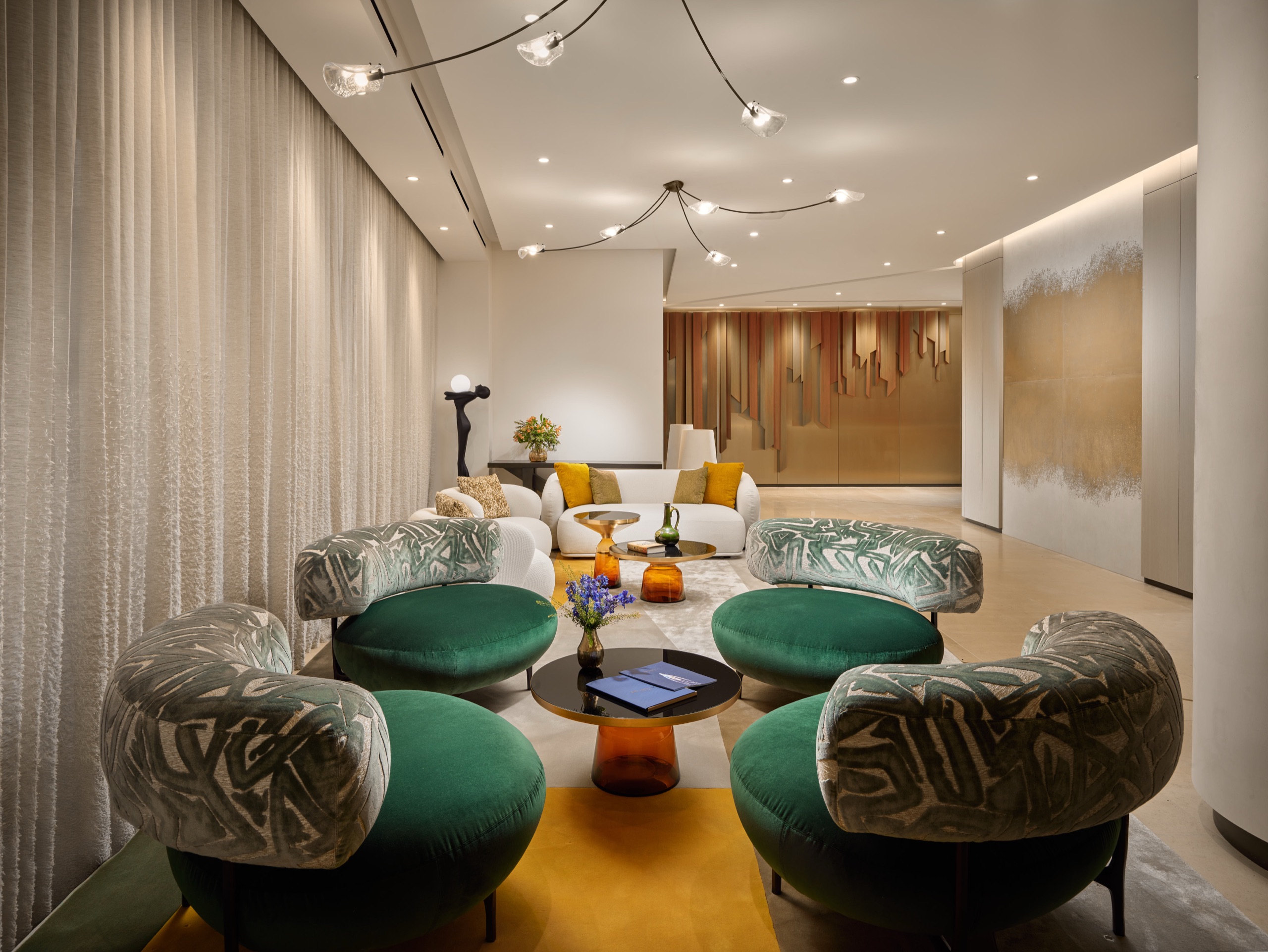 The residential lobby: emerald chairs against a bronze skyline relief