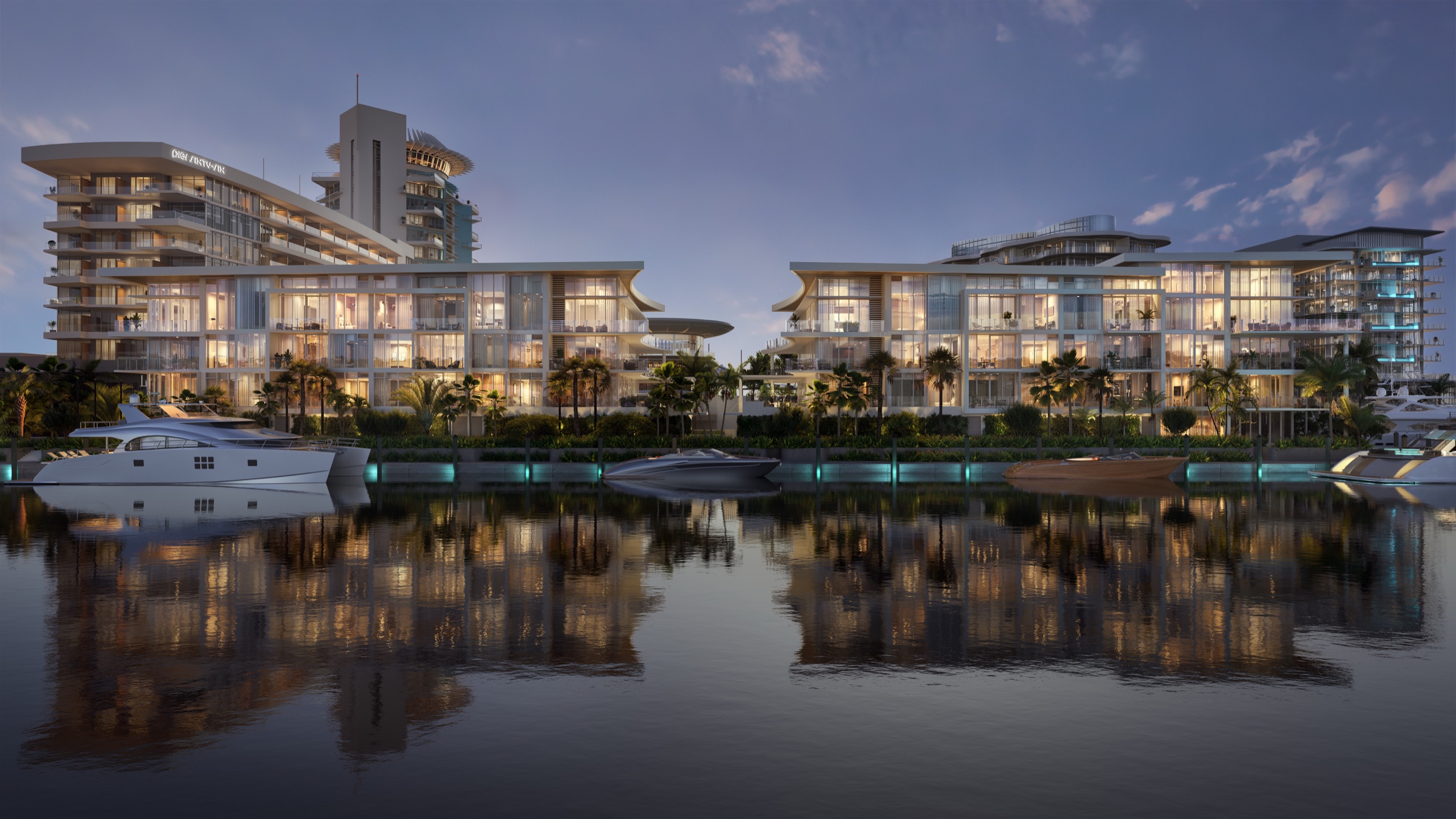 The Resort Residences glowing across still water at dusk